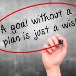 Man Hand writing "A goal without a plan is just a wish" black marker on visual screen. Business, technology, internet concept.